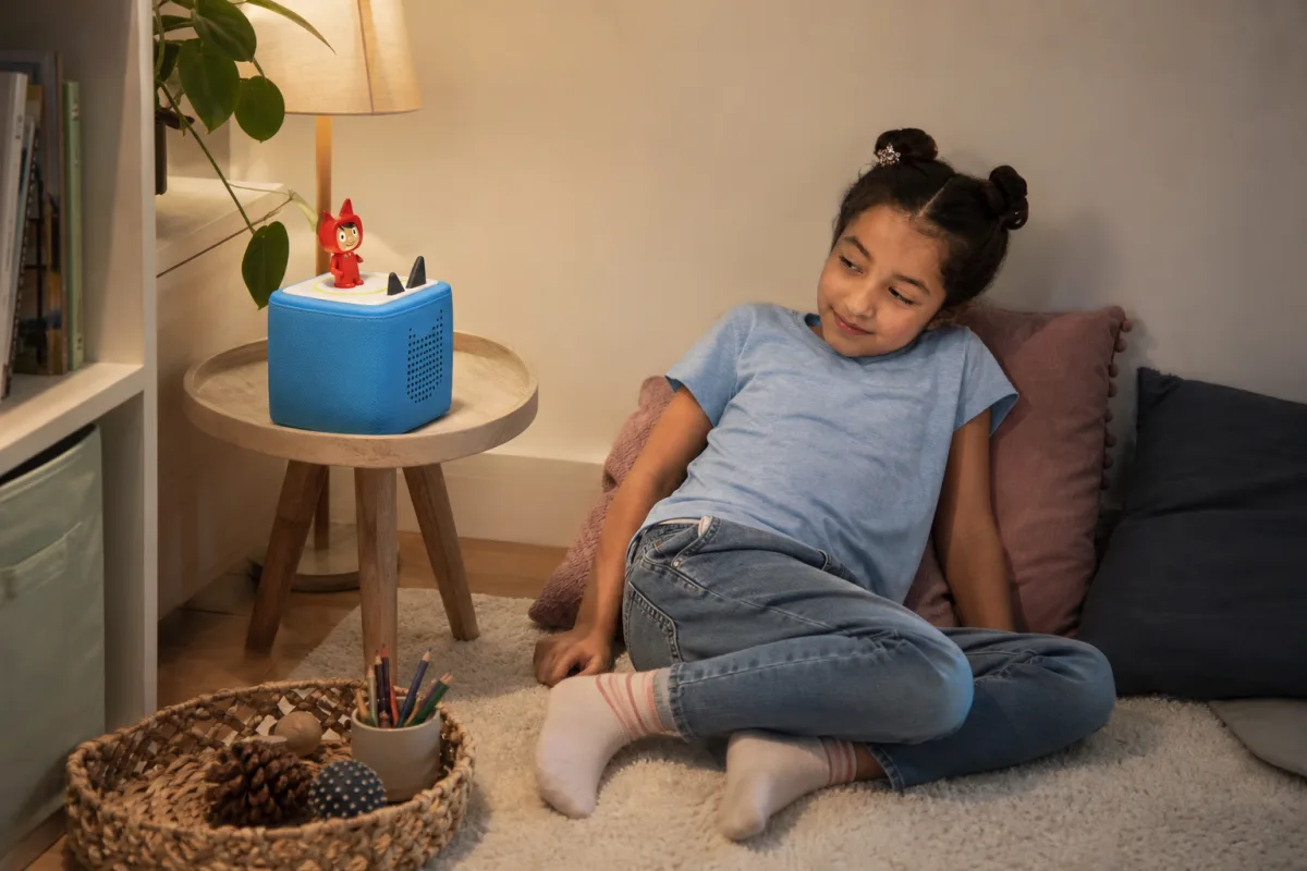 Enfant installé dans un coin calme avec une Toniebox bleue