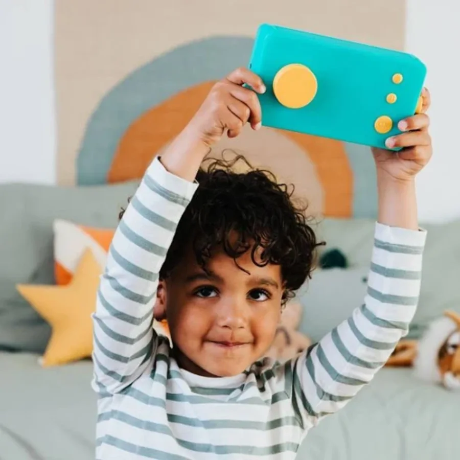 Enfant tenant une Fabrique à Histoires Lunii turquoise